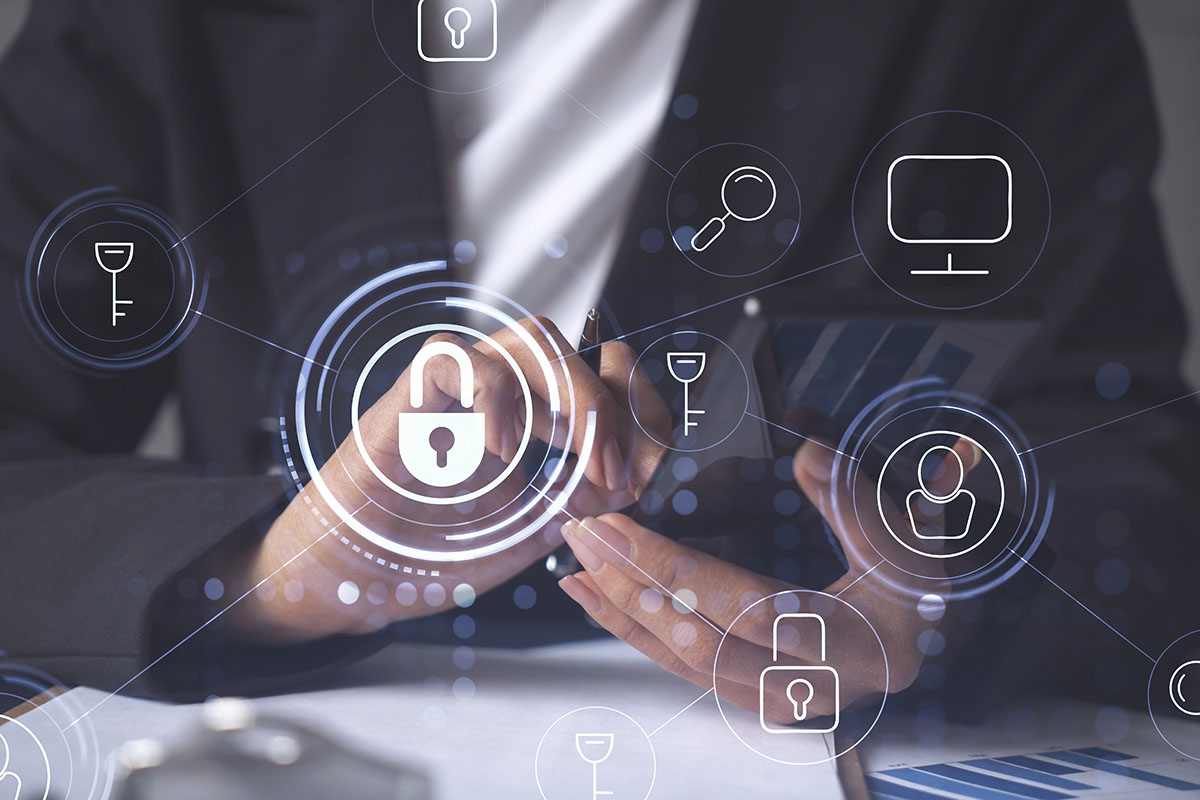 A close-up of a person's hands holding a smartphone and a pen, with various digital security icons, including a padlock and key, overlaid in soft focus, suggesting themes of cybersecurity and data protection.